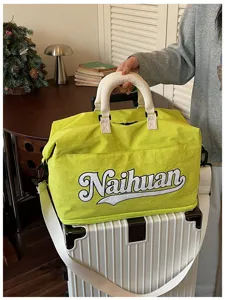 Moderna bolsa de viaje verde neón con letras llamativas, correa para el hombro y asas resistentes.