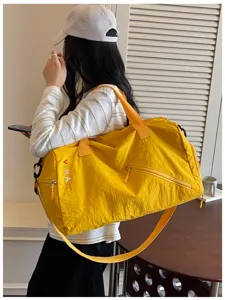 Vista detallada de la bolsa de viaje amarillo brillante con correa, ideal para gimnasio y yoga.