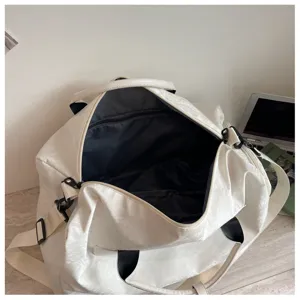Vue rapprochée de l'espace intérieur et de la poche zippée du sac de voyage léger.