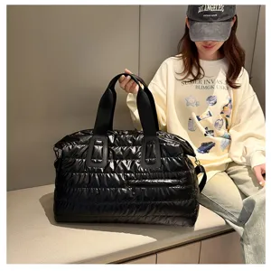 Detailed view of black puffy travel duffel bag showing soft quilted texture and durable handles.
