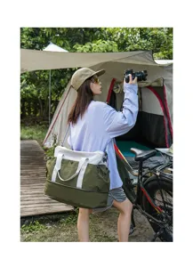 Outdoor camping scene detail of a color-blocked travel duffel bag carried by a model.