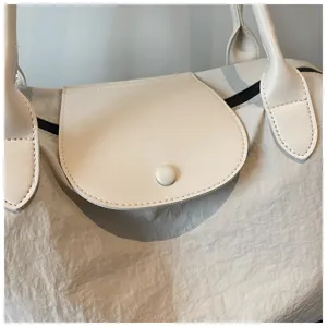 Detailaufnahme der beigen Nylon Reisetasche mit Lederklappe und Griffen fuer den Alltag.