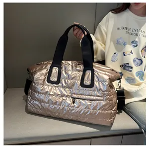 Metallic gold quilted travel duffel bag with black straps, stylish fitness and sports luggage storage.