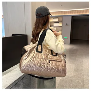 Detailed lifestyle view of the shiny gold quilted travel duffel bag with comfortable straps.