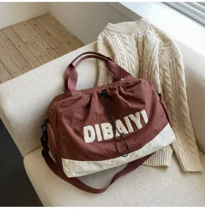 Detailed view of the stylish travel duffel bag with shoulder strap and front letter patch.