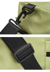 Détail de sangle de sac de voyage, quincaillerie plastique noire et tissu résistant vert.