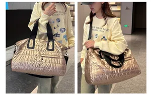 Detail view of the metallic gold quilted duffel bag, showing soft puffer texture and capacity.