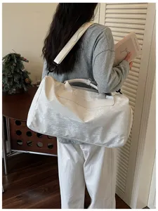 Gros-plan d'un sac de voyage blanc et léger doté d'une bandoulière pratique pour la salle de sport.