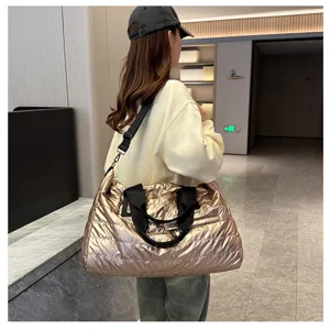 Large metallic gold puffer travel bag, stylish quilted duffel bag for gym and weekend trips.