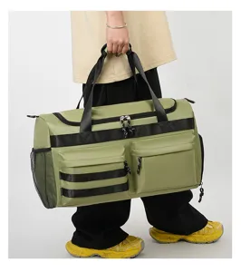 Détail de sac de voyage grand format avec poignées résistantes et poches avant zippées.