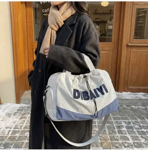 Detailed shot of a stylish canvas travel duffel bag with contrast color and drawstrings.