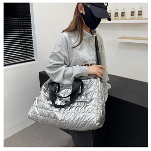 Silver metallic puffer tote bag detail shot, large capacity travel luggage and sports gym bag.