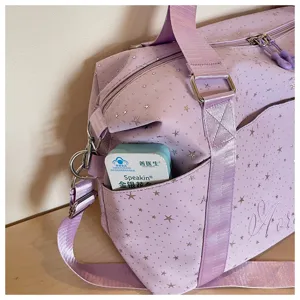Purple travel duffel bag with star print, detail view of side pocket and strap buckle.