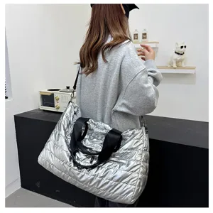 Silver padded travel duffel bag scene detail, quilted puffer crossbody bag lifestyle view.