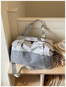 Detailansicht der grauen Reisetasche mit strapazierfähigem Musterstoff und stabilen Gurten.
