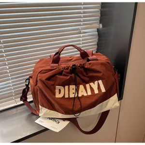 Detail view of stylish casual travel duffel bag with contrast color design and sturdy handles.