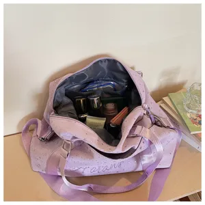 Detailed view of large capacity purple star print travel duffel bag interior organization.