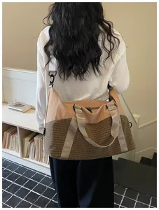 Detailansicht der stylischen Reisetasche im Blockdesign mit robusten Gurten und Karo-Muster.