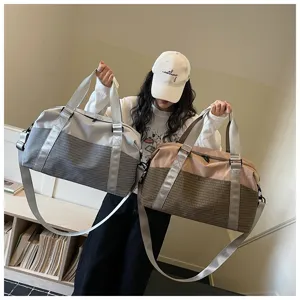 Detailaufnahme einer stilvollen zweifarbigen Reisetasche mit Griffen und Schultergurt.