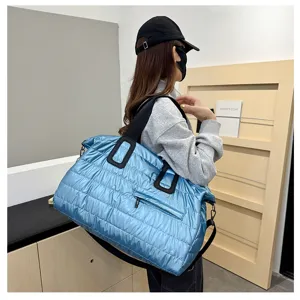 Large quilted puffer travel bag with shoulder strap, casual blue weekender tote for fitness and gym.