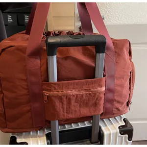 Travel duffel bag with trolley sleeve and durable nylon fabric for business trips or weekend getaways.