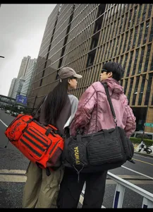 Urban street style detail shot showing large capacity multi-pocket sports travel duffel bag.