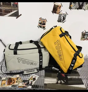 Detailed view of large capacity waterproof travel duffel bag in yellow and grey colors on shelf.