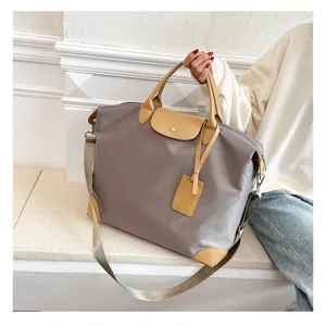 Large capacity waterproof nylon travel duffel bag with leather trim and shoulder strap.