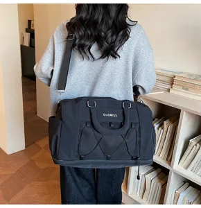 Detail view of the black travel duffel bag showcasing side pockets and durable shoulder strap.