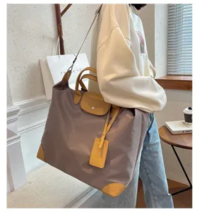 Close-up detail of large nylon travel tote bag with leather trim and stylish shoulder carry.