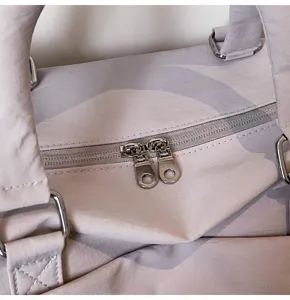 Detailed view of light purple travel gym bag with double zippers and durable hardware for women