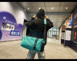 Cyan travel duffel bag detail, large capacity sports gym bag with shoulder strap and handle.