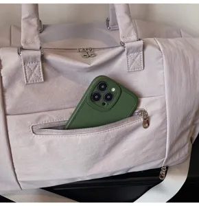 Close-up detail showing the front zippered pocket of a stylish pink travel duffel gym bag.