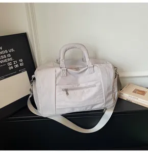 Stylish casual travel duffel bag with shoulder strap, gym and sports bag in light grey.