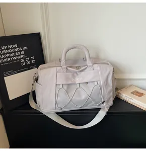 Detailed view of the stylish travel duffel bag with mesh pocket and bungee cord design.