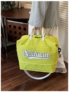 Vista detallada de la bolsa de viaje verde brillante con estampado de letras y asas.