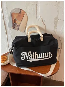 Bolsa de viaje negra con asas y correa contrastantes blancas para viajes cortos y deporte.