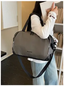 Detail shot of stylish color-matching travel duffel bag, casual shoulder commuting bag.