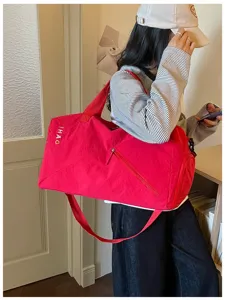 Vista detallada de una bolsa de viaje roja para deportes, fitness, yoga y uso al aire libre.