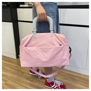 Pink plaid travel handbag detail featuring front zipper pocket, sturdy handle and strap.