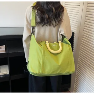 Detail view of the large capacity green travel duffel bag with convenient shoulder strap and handle.