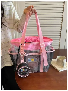 Detail view of the pink and black mesh beach bag, showing side pockets, durable handles and pouch.