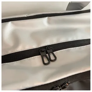 Silver and black travel bag detail showing smooth double zippers and waterproof fabric.