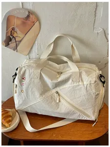 Vista detallada de la bolsa de viaje blanca informal con cremallera duradera y correa.