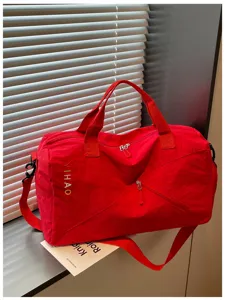Detalle de bolsa de viaje deportiva roja, bolso de hombro de nylon con bolsillo diagonal