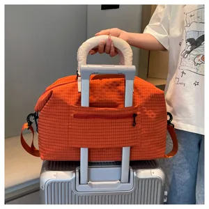 Orange plaid travel duffel bag with trolley sleeve and shoulder strap for weekend trips.