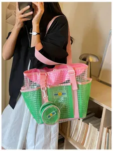 Grid shoulder bag detail, transparent PVC, pink and green color contrast, with a small pouch.