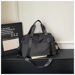 Detailansicht der stilvollen schwarzen Reisetasche Sporttasche mit Karomuster und Gurten.