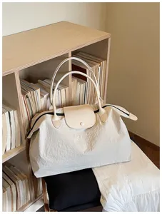 Detaillierte Nahaufnahme der leichten, beigen Reisetasche in gemütlicher Kulisse.