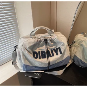 Detail view of a stylish short-trip travel duffel bag with contrast blue and grey color blocking.